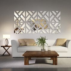 a living room with white furniture and mirrors on the wall