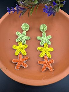 This is a beautiful Quirky beaded Earrings in Multicolor 3 level star design is very light weight to wear and looks good on any attire. This is very beautiful to look at and a perfect one for regular wear and also parties.  Color : Green, Pink length : 3.75 inch width : 1.25 inch Each earring Weight : 5.9 grams Material : Beads, Fabric Beautiful High Quality, premium jewelry. Free US standard shipping. Hand crafted in India with the finest design, this earring is of premium quality and unique de Handmade Bohemian Flower Earrings For Party, Whimsical Adjustable Beaded Earrings, Beaded Flower Dangle Earrings For Beach, Bohemian Beaded Flower Earrings For Party, Handmade Star Earrings For Festivals, Handmade Star-shaped Festival Earrings, Handmade Whimsical Beaded Drop Earrings, Bohemian Star-shaped Beaded Jewelry, Bohemian Party Earrings With Tiny Beads