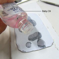 a person is holding a baby oil bottle