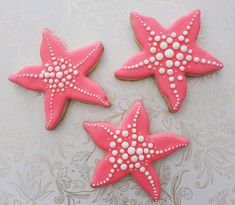 three decorated starfish cookies sitting on top of a table