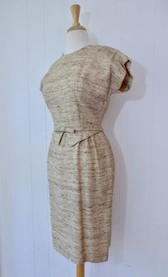 Ultra chic vintage 60's wiggle dress!Features include:Beautiful stubbed linen blend dress in a flattering neutral shade of beigeCute bow and peplum detail at waistlineDress is fully lined, metal zips up the backEra:1950'sMeasurements of dress:Around chest, underneath armpits - 38"Across waist - 26"Across hips - 37"Top of shoulder to bottom hem - 40"No size labeled. Please consult measurements for an accurate fit!All garments measured lying flat across front & doubled. Please compare measurem Chic Fitted Vintage Dress In Beige, Chic Fitted Beige Vintage Dress, 1950s Style Fitted Cream Vintage Dress, Fitted Beige Retro Dresses, Cream Fitted 1950s Style Dress, Cream Fitted Dress In 1950s Style, Fitted Cream Dress In 1950s Style, Fitted Cream Vintage Dress Chic Style, Chic Fitted Cream Vintage Dress