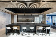 a kitchen with an island and bar stools in the center, surrounded by blue walls