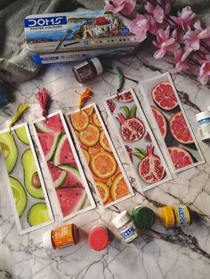 several pictures of different fruits and vegetables on a marble table with paint, glue, and other items