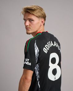 a man with blonde hair wearing a black jersey