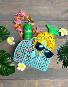 various items laid out on top of a wooden table next to plants and flowers, including sunglasses