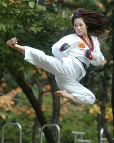 a woman is in the air doing karate