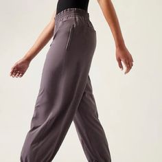 Athleta Dusk Violet Savannah Jogger Athletic Lounge Pant A Classic Pair Of Lightweight Trouser Joggers From Athleta In The “Savannah” Style In The “Dusk Violet” Color. These High-Waisted Pants Feature An Elasticized Paper Bag Waist With Zippered Side Pockets, Back Pockets, And A Tapered Leg With Elasticized Ankles. They Can Be Styled Many Different Ways And Will Level Up Any Casual Outfit. Very Stretchy And Comfortable For All Day Wear. Made From 86% Polyester And 14% Spandex. New With The Origi Sporty Full-length Spring Joggers, Sporty Full Length Spring Joggers, Yoga Sportswear Joggers With Relaxed Fit, Spring Activewear With Elastic Waistband For Training, Athleisure Style Yoga Sweatpants With Elastic Waistband, Athleisure Sweatpants With Elastic Waistband For Yoga, Sporty Yoga Joggers With Loosely Fitted Hips, Spring Activewear For Training With Elastic Waistband, Sporty Yoga Sweatpants With Elastic Waistband