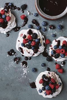 three desserts with berries and whipped cream on them