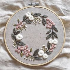 an embroidered wreath with flowers and leaves