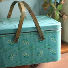 a blue box sitting on top of a wooden table next to a potted plant