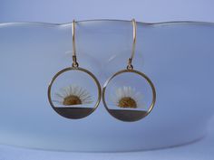 These small round brass frames that are evocative of the sun on the horizon hang from 24k gold plated ear hooks. Available in your choice of real preserved botanical: Queen Anne's Lace is a symbol of sanctuary The Daisy is a symbol of hope Forget-me-nots are known as a symbol of lasting friendship, love, and remembrance Materials are tarnish resistant. However, please see our care section for info on keeping your piece lovely for years to come. All materials are nickel and lead free. Ships in a Yellow Gold Circle Brass Earrings, Yellow Gold Circle Earrings In Brass, Pierced Yellow Gold Flower Earrings, Pierced Round Yellow Gold Flower Earrings, Yellow Gold Pierced Flower Earrings, Nature-inspired Round Brass Earrings, Yellow Gold Round Pierced Flower Earrings, Brass Round Flower Earrings, Adjustable Gold Round Flower Earrings