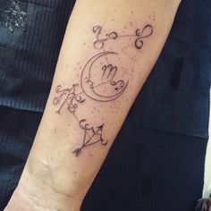 a person with a tattoo on their arm that has the moon and stars in it