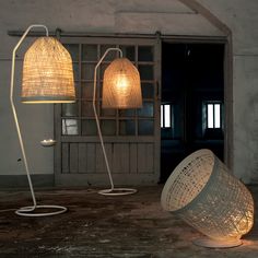 three lamps sitting on top of a wooden floor next to an open door and window