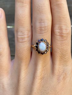 Total Weight: 2.9 grams Size: 6.75 Band Width: 1.4-4.2mm Ring Face: 14.2x12.2mm Opal: 7.7x5.8mm Cubic Zirconia: 2mm Condition: In great condition showing little wear with no damage. All gold has been thoroughly checked with an Olympus XRF spectrometer. It is guaranteed 14k gold.  All our jewelry is properly washed and disinfected to ensure customers get clean items with every order.  Returns accepted but may be subjected to a restock fee.  Please message with any questions:) 14k Gold Birthstone Cluster Ring, Cluster Halo Ring In Yellow Gold For Gift, White Cluster Ring Stamped 14k, White Ruby Ring In 14k Gold, Classic White Oval Ruby Ring, White Oval Ruby Ring, Oval White Ruby Ring, Fine Jewelry With Halo Cluster, White Oval Sapphire Gemstone Ring