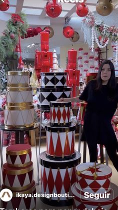 a woman is standing in front of many red and white christmas decorations