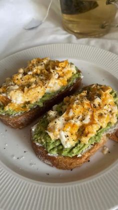 two pieces of bread with cheese and other toppings on it sitting on a plate