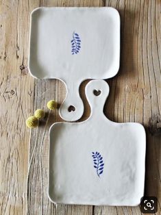 two serving trays with designs on them sitting on a wooden table next to each other