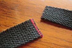 two crocheted pieces of cloth sitting on top of a wooden table