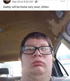 a man wearing glasses sitting in the back seat of a car with dirt on it