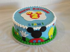 a mickey mouse birthday cake on a white tablecloth with the name happy birthday i am