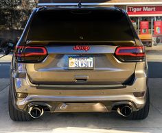 the rear end of a jeep parked in front of a gas station with its license plate