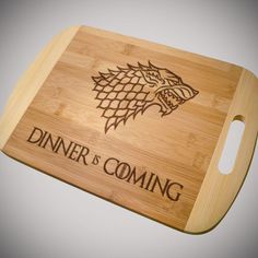 a cutting board with the words dinner is coming on it and a game of thrones logo