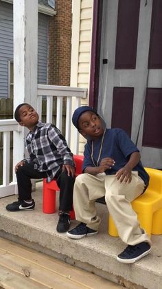 two young boys sitting on the front steps of a house