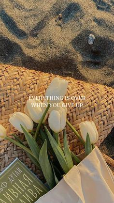 some white flowers and a book on the sand