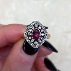 This antique ring was handcrafted during the Edwardian era and features a bezel-set 0.75ct sugarloaf cut natural ruby. The ruby is surrounded by a halo of single cut diamonds, followed by a second halo of rose cut diamonds. This ring is platinum on 18k yellow gold and decorated with fine milgrain. Circa 1905. ✦ GEMSTONE SPECIFICATIONS: Gemstone: Ruby Gemstone Weight: 0.75 Carats Gemstone Cut: Sugarloaf Cut ✦ ENGAGEMENT RING SPECIFICATIONS: Material: Platinum on 18k Yellow Gold Stones: Diamond, R Edwardian Ruby Ring, Estate Diamond Jewelry, Platinum Engagement Ring, Diamond Halo Engagement Ring, Antique Ring, Platinum Engagement Rings, Engagement Ring Cuts, Edwardian Era, Halo Diamond Engagement Ring