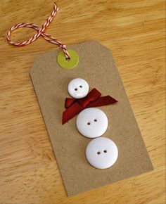 two white buttons with a red bow are on a piece of brown paper next to a candy cane