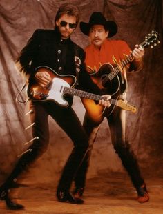 two men are posing with guitars in their hands