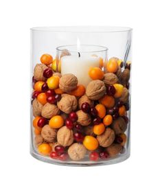 a glass filled with nuts and a candle