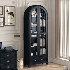 a tall black bookcase with glass doors in a living room