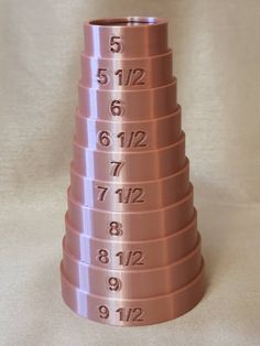 a stack of pink metal cups with numbers on the side and one in the middle