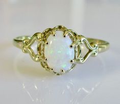 This is a vintage 9ct gold ring, set with an oval opal which is 0.65 carats in size. the band width is 8mm at the front down to 1mm at the back. It is a UK size P or a US size 7 1/2. Hallmarked 9ct gold,  made in London in 1981, it weighs 1.4 grams. 724. Classic Oval Hallmarked Opal Ring, Classic Gold Opal Oval Cabochon Ring, Classic Opal Oval Cabochon Promise Ring, Classic Opal Oval Cabochon Ring For Promise, Classic Gold Opal Ring With Oval Cabochon, Classic Oval Cabochon Opal Promise Ring, Classic Opal Promise Ring With Oval Cabochon, Classic Gold Oval Opal Ring, Classic Oval Cabochon Opal Ring For Formal Occasions