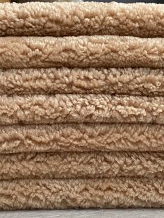 a pile of tan colored rugs sitting on top of a wooden floor