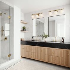 a bathroom with two sinks and mirrors in it