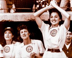 three women in white uniforms are holding their hands up above their heads while standing next to each other