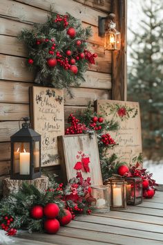 christmas decorations and candles are on the side of a cabin wall with pine cones, red berries