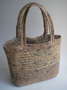 a woven bag is shown on a white surface with the handles folded back to show it's natural texture