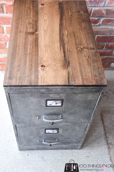 an old metal filing cabinet with wood grained finish on the top and bottom drawers