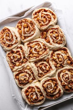 cinnamon rolls are arranged on top of each other in a baking pan, ready to go into the oven