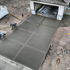 two men are working on an asphalt driveway