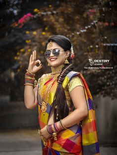 a woman in a colorful sari holding her hand up