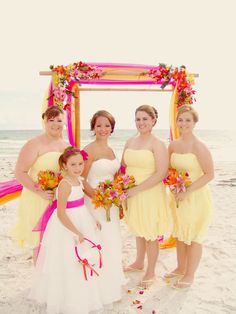 a group of women standing next to each other on a beach