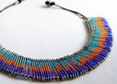 a multicolored beaded necklace on a white surface