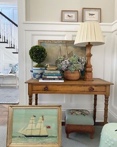 a living room with a table and pictures on the wall