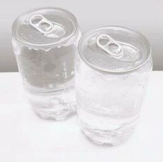 two empty soda cans sitting next to each other on top of a white countertop