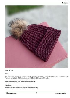 a knitted hat with a pom - pom sits on top of a pink object