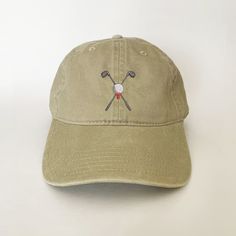 a baseball cap with two golf clubs embroidered on it